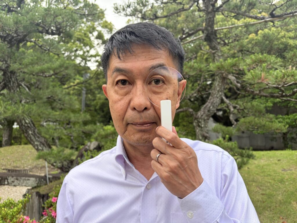 ルティーナを目元にかざした男性の画像
