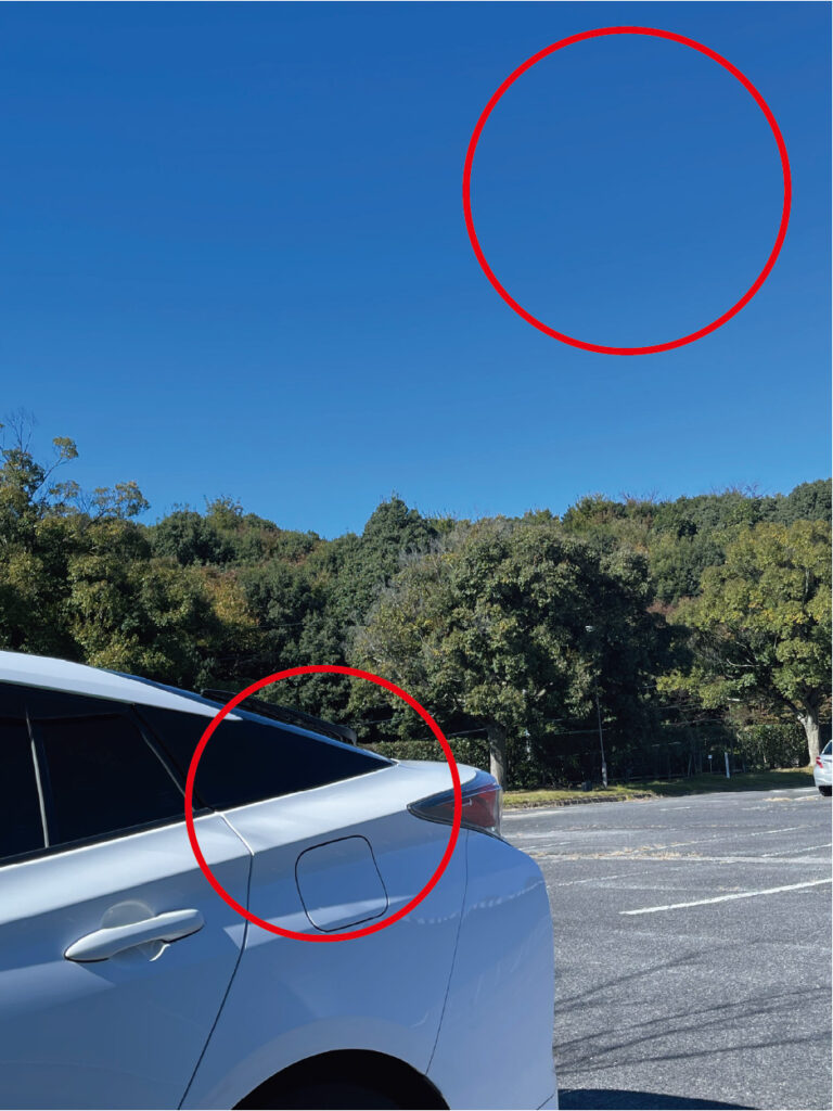 ブルーレンズによる見え方の比較画像。レンズなしとブリーズブルー着用時で、車のボディの反射が抑えられ、空の青さが際立つ様子を並べて示している。
