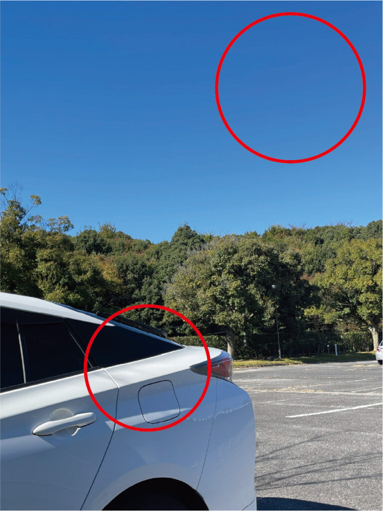 ブルーレンズによる見え方の比較画像。レンズなしとブリーズブルー着用時で、車のボディの反射が抑えられ、空の青さが際立つ様子を並べて示している。